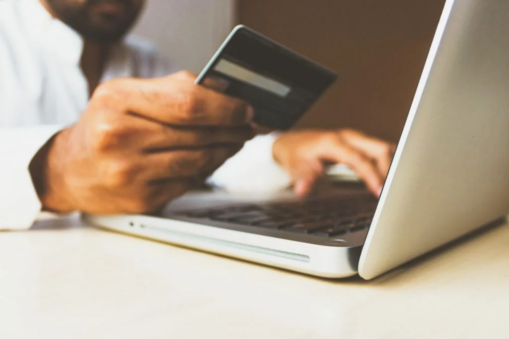 A man holding a credit card to buy from online dealers