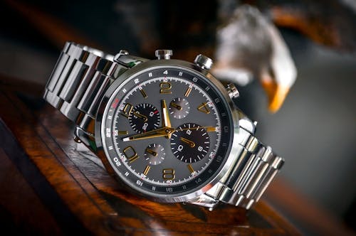 Silver chronograph watch on wooden surface