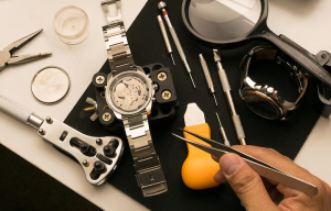 Watchmaking tools and components arranged neatly.