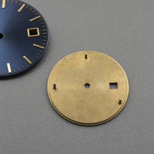 Two watch dials, one blue, one gold.