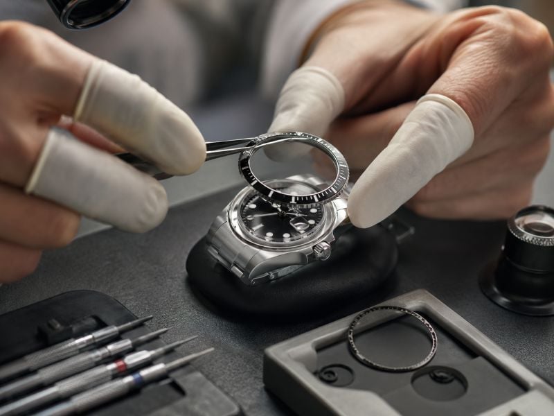 Watchmaker installing bezel on Rolex